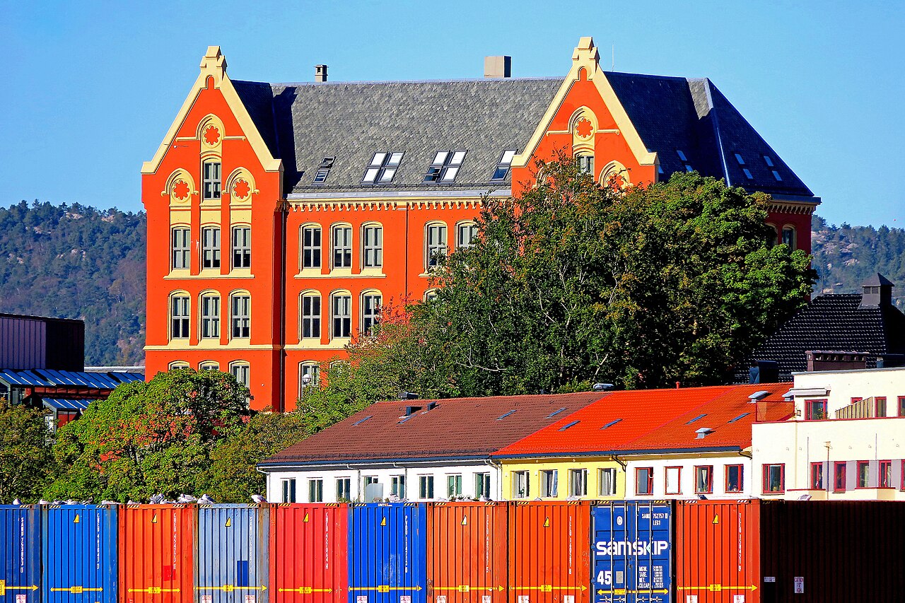 Dragefjellet skole sett fra sjøsiden med havneområdet Dokken i forgrunnen og Bergen by i bakgrunnen