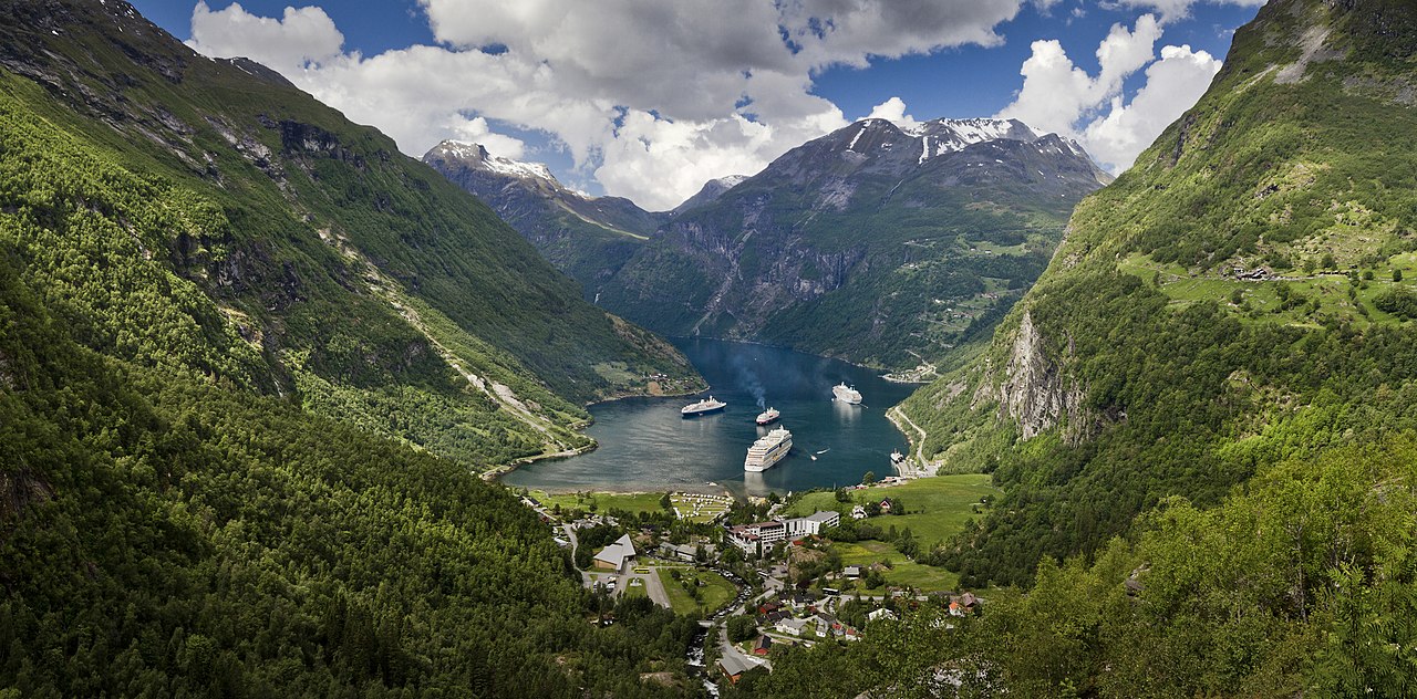 Utsikt over Geiranger og Geirangerfjorden fra Flydalsjuvet med grøne fjellsider og turkis fjordvatn