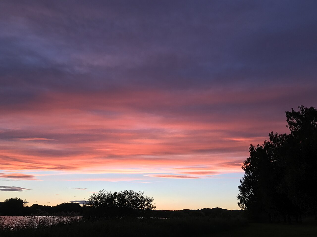 Solnedgang med rosa og lilla skyer over Lillestrøm, sett mot bebyggelsen