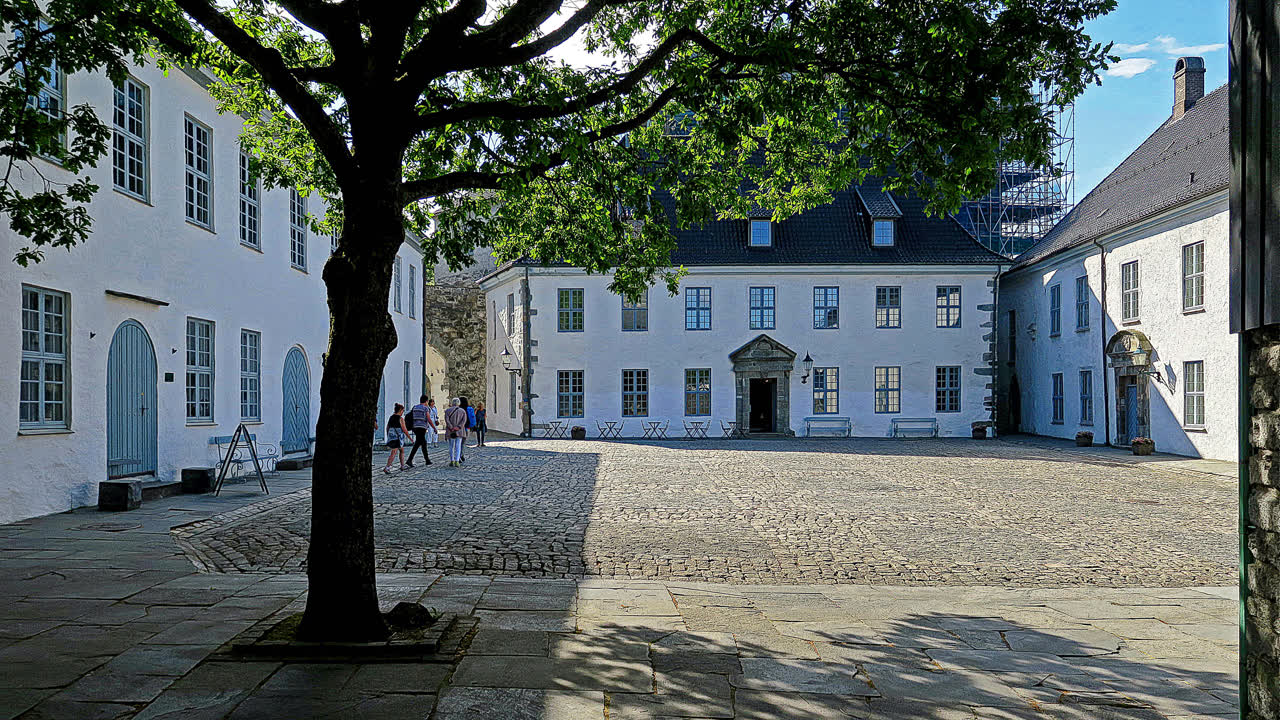 Slottsgården på Bergenhus festning i Bergen, med de historiske hvite bygningene og brosteinsplassen