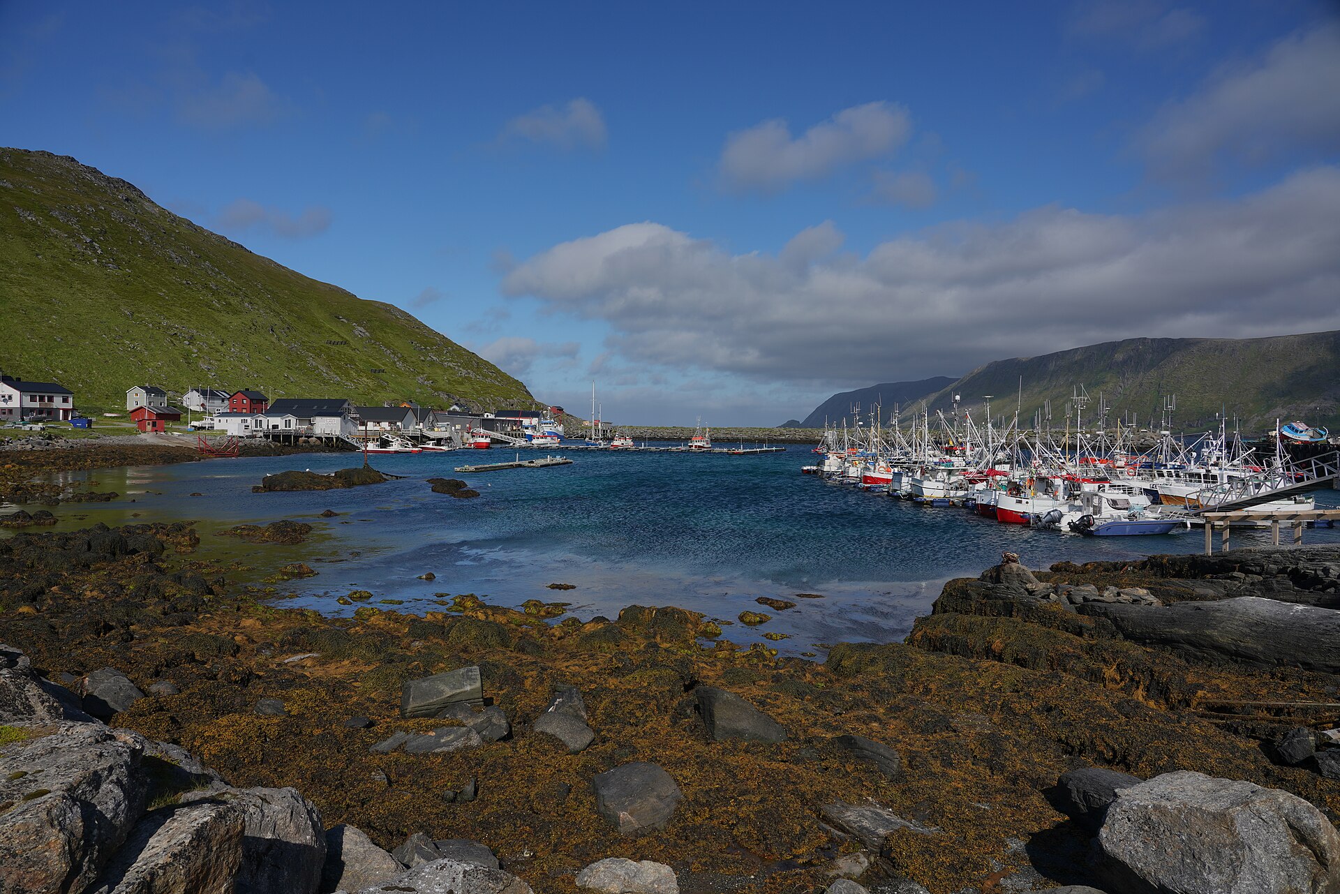Brygga og havna i Skarsvåg fiskevær på Magerøya, med fiskebåter, kai og fjell i bakgrunnen