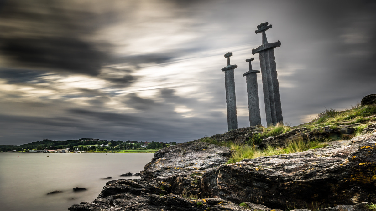Sverd i fjell ved Møllebukta i Stavanger i solnedgang, tre monumentale sverd reist i stein ved Hafrsfjord