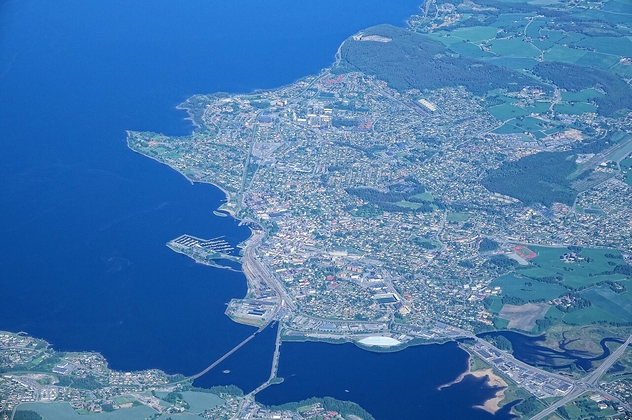 Flyfoto over Hamar by og Mjøsa, der Tjuven Musikkfest arrangeres ved Tjuvholmen Arena