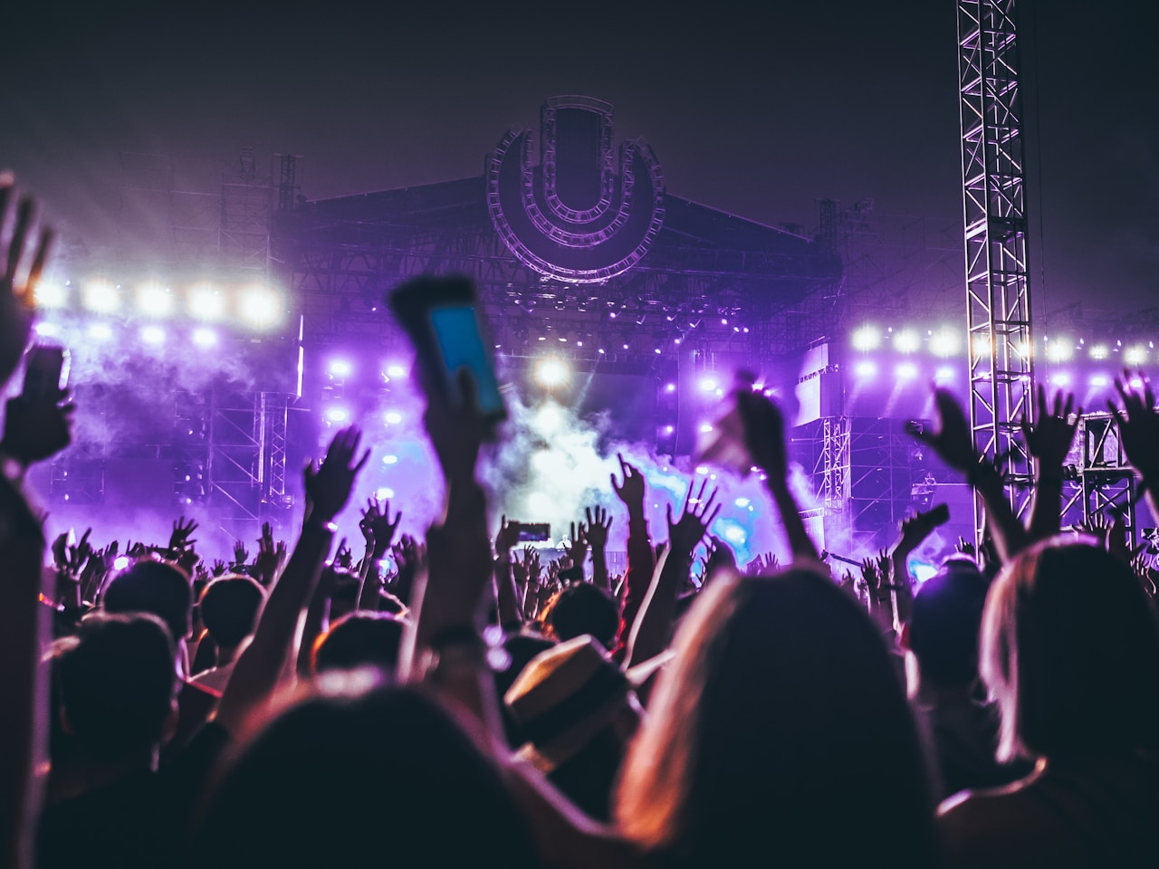 Konsertpublikum med høye hender og scenelys - kjøp billetter trygt via Hoopla