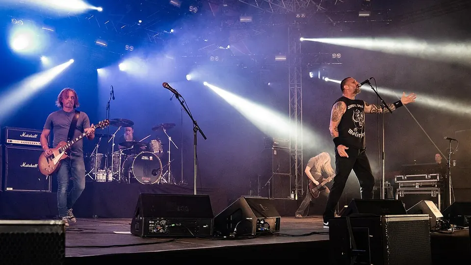 Scenelys over et band på scenen under en konsert i Norge